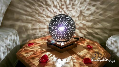 马拉喀什里亚德画廊49号庭院旅馆的木桌上的一盏灯,上面有红心