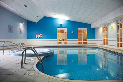 迪德科特米尔顿山之家酒店的一座拥有蓝色墙壁的大型游泳池