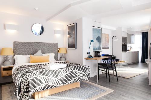 伦敦罗克韦尔东塔桥公寓式酒店的卧室配有黑白床和书桌。