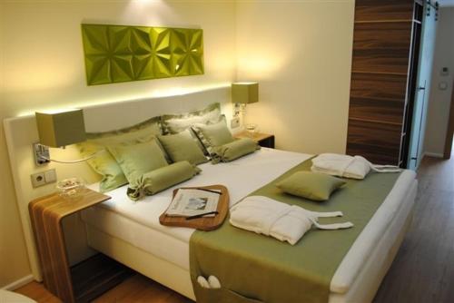 赖讷莱茵博物馆高尔夫酒店的一间卧室配有一张带绿色枕头的大床