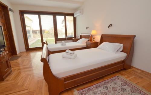 克拉多沃Mladenovic apartments的一间卧室配有两张床和电视