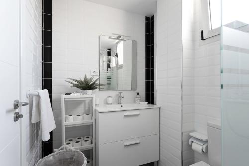 洛斯克里斯蒂亚诺斯Almar Apartamento en Los Cristianos con AC的白色的浴室设有水槽和镜子
