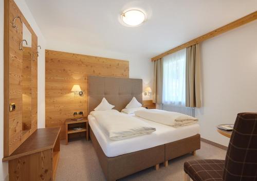 塞尔瓦迪加尔代纳山谷Garni Lanzinger的配有一张床和一张书桌的酒店客房