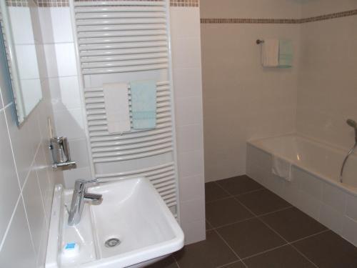 韦兰健康酒店的白色的浴室设有水槽和浴缸。