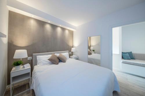 加达湖畔帕登赫Italia Living Villa的白色卧室设有一张大床和镜子