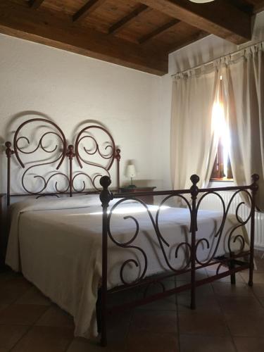 瓜尔多塔迪诺Casale degli ulivi的一间卧室配有一张带白色毯子的床和窗户。