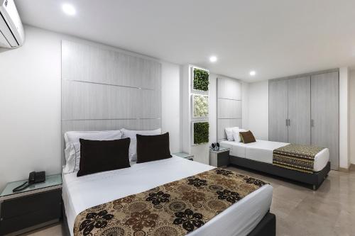 麦德林Hotel Madeiro的一间卧室设有两张床和窗户。