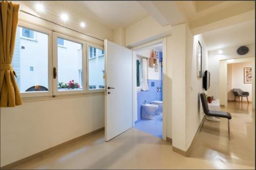 佛罗伦萨Arch Apartment Duomo - Florence的走廊设有门,通往带卫生间的浴室