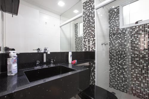 圣保罗AP EXPOCENTER - ATÉ 5 HOSPEDES的浴室设有黑色水槽和镜子