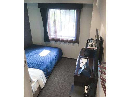 冈山HOTEL LiVEMAX Okayama的一间小卧室,配有床和窗户