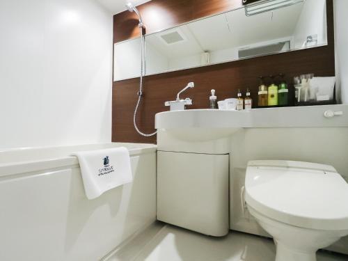 东京HOTEL LiVEMAX Tokyo Shintomicho的浴室配有白色卫生间和盥洗盆。
