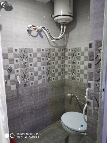 瓦拉纳西New Hotel Yatri Niwas的一间带卫生间和淋浴的小浴室