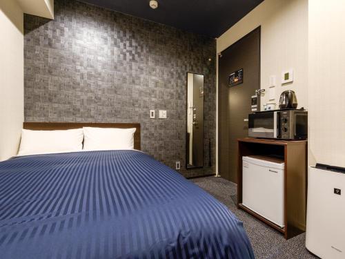 东京HOTEL LiVEMAX Asakusabashi-Ekimae的酒店客房带一张床和一台微波炉
