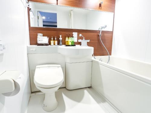 横滨HOTEL LiVEMAX Yokohama-Eki Nishiguchi的浴室配有卫生间、盥洗盆和浴缸。