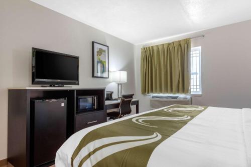 科里奥波利斯Quality Inn Coraopolis的配有一张床和一台平面电视的酒店客房