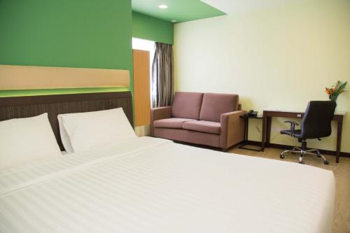 斯里巴加湾市首都居所套房酒店的一间卧室配有一张床、一把椅子和一张书桌