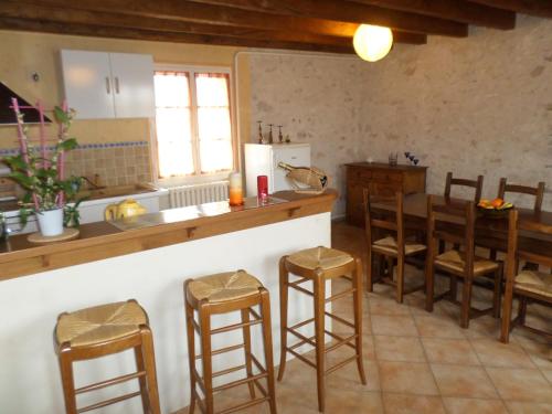Lailly-en-Valgite l'opale的厨房配有柜台和一些木凳