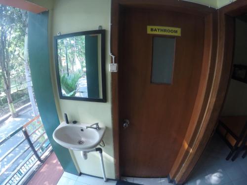 庞越Dhika Adventure的一间带水槽的浴室和一个带镜子的门