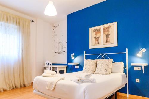 乌贝达Apartamentos Turísticos Architettura Úbeda的蓝色的卧室,配有床和蓝色的墙壁
