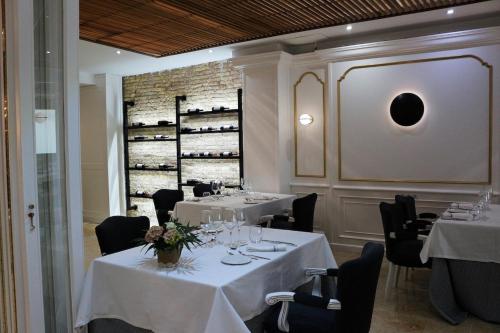 卡塔赫纳罗斯哈巴内罗斯酒店的餐厅设有白色桌椅和葡萄酒架