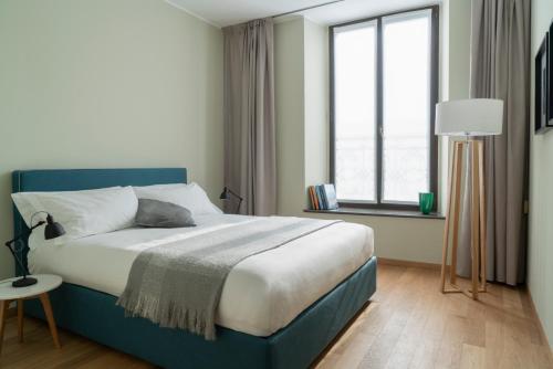 米兰布雷拉斯卡拉公寓的一间卧室设有蓝色的床和窗户。