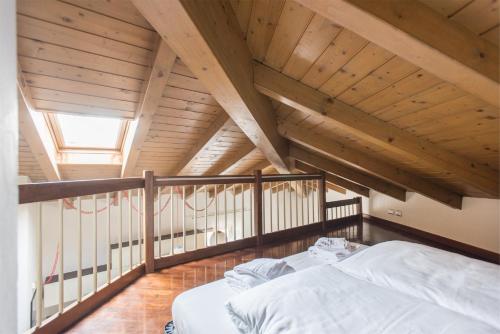 阿科Casa Lidia, la mansarda sul fiume的木天花板的客房内的一张床位