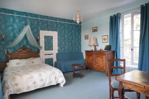 布里阿尔Appartements détente & nature - Domaine de La Thiau的一间卧室配有一张床、一把椅子和一张桌子