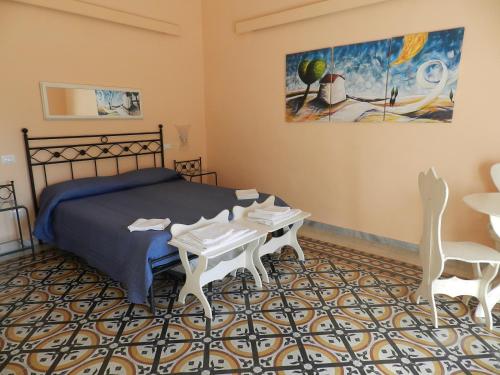 维耶特里villa verde sul mare的卧室配有一张床和一张桌子及椅子
