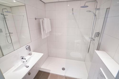 希佛萨姆兰佩夏克阿伦那帕阿姆拉酒店的带淋浴和盥洗盆的白色浴室