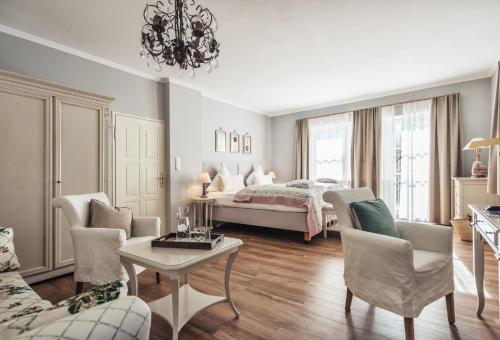 明辛奥贝姆巴赫城堡拜尔酒店的卧室配有一张床和一张桌子及椅子