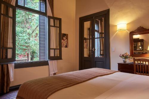 布宜诺斯艾利斯科波拉雅尔丹埃斯孔迪多比翼酒店的一间卧室设有床、两个窗户和镜子