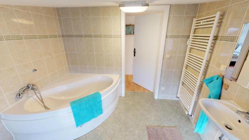 沃尔加斯特Altes Warmbad Wolgast的带浴缸和盥洗盆的大浴室