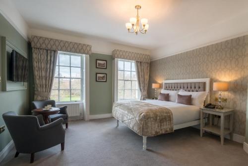 都柏林斯坦顿格林酒店的一间卧室配有一张床、一把椅子和窗户。