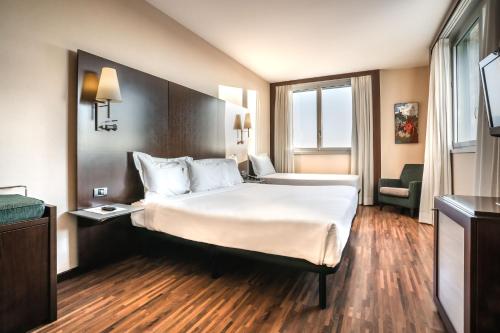 利沃诺麦克斯利沃诺酒店的一间设有大床和窗户的酒店客房