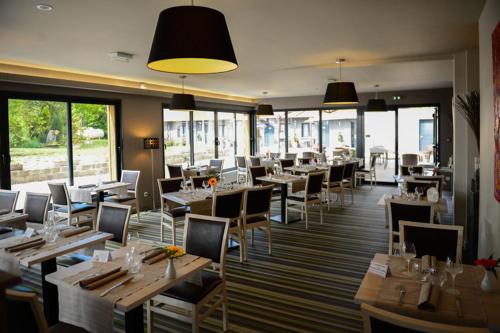拉勒塞勒罗吉斯林提勒尔酒店（科特迪瓦PARC餐厅）的餐厅设有木桌、椅子和窗户。
