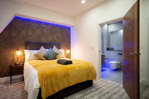 利兹Leeds Super Luxurious Apartments的一间卧室配有一张带黄色毯子的大床