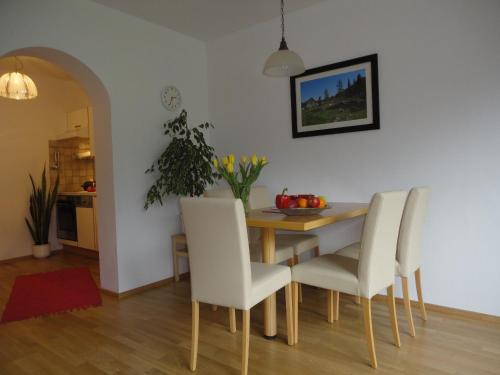 阿布特瑙Ferienwohnung Ronacher的一间带桌子和白色椅子的用餐室