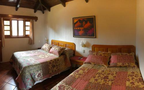 帕纳哈切尔Posada De Los Volcanes的一间卧室设有两张床和窗户。