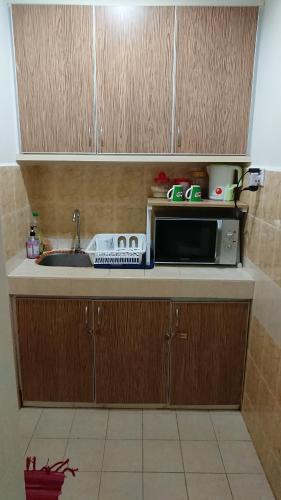 哥打巴鲁AlRayani Guest Room, Homestay Kota bharu的厨房柜台配有微波炉和水槽