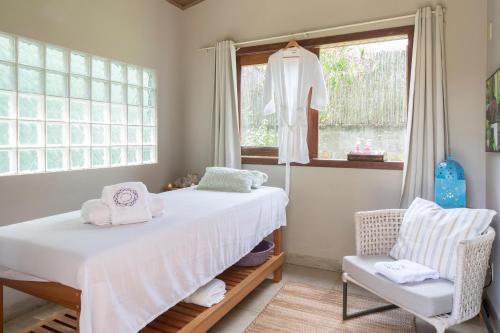 戈亚斯州上帕莱索鲁阿波萨达旅馆的卧室配有床、椅子和窗户。