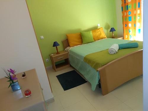 波尔蒂芒Lita Apartment的一间卧室配有橙色和绿色的床