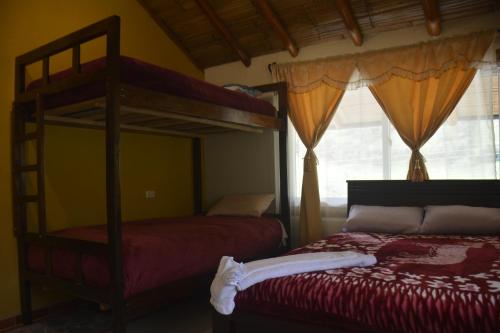 帕帕亚克塔SOL DE PIEDRA的一间卧室设有两张双层床和一扇窗户。