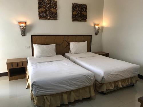 乌隆他尼UD Residence的配有白色床单的酒店客房内的两张床