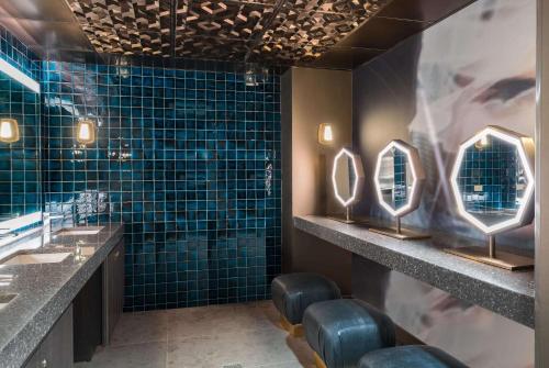 纽瓦克纽瓦克市区特瑞普酒店 的浴室设有2个水槽、镜子和蓝色瓷砖