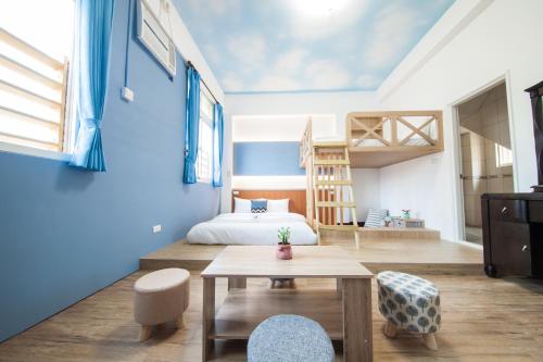 马公起点旅行的一间拥有蓝色墙壁的卧室,配有一张床和一张桌子
