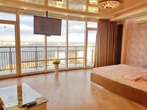 第聂伯罗莫斯特城市公寓式酒店的一间卧室设有一张床,大窗户配有电视