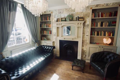 伦敦斯文顿酒店的客厅配有黑色真皮沙发和壁炉