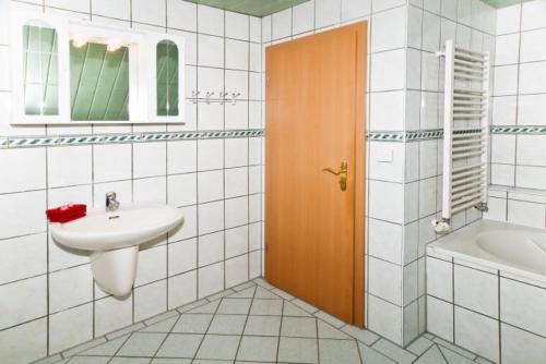 奥斯赛拜-屈隆斯博恩Ferienhäuser - Doberaner Straße的浴室配有盥洗盆、卫生间和浴缸。