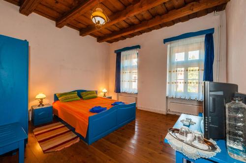 SaschizPension Cartref的一间卧室设有蓝色的床和2个窗户。