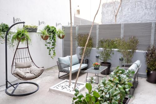 雅典Hercules Residence的庭院设有椅子和盆栽植物
